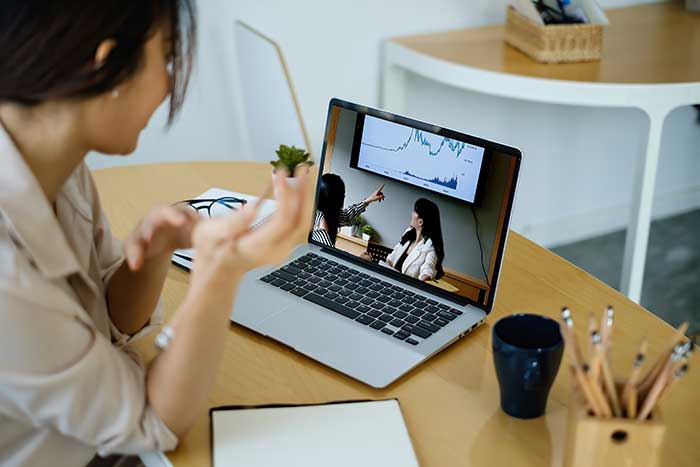 Rear view of female employee meeting via video call with employee