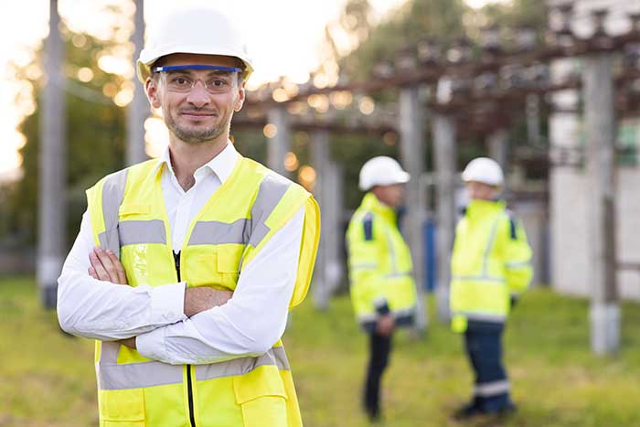 Male engineer technologist standing among high voltage electrical lines