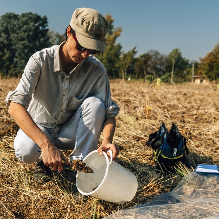 Woman obtaining a soil sample